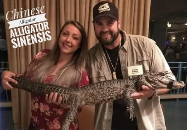 Jimmy Riffle with his partner Sara Barber holding an alligator